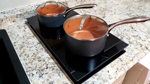 Two black pots with transparent lids on a black induction cooktop. - Altamonte Luxury Studio: Shops, Parks (Altamonte Springs)