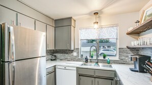 A modern kitchen with stainless steel appliances, a dishwasher, and a window with a view of the outside. - Updated Duplex Home < 1 Mi to Downtown Enumclaw! (Enumclaw)