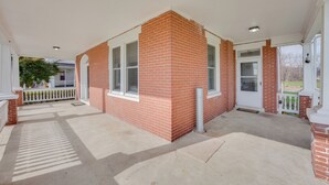 A covered porch area with a brick building, white railings, and a concrete floor. - 15 Mi to Amish Village: Cozy Lancaster Apt! (Lancaster)