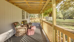 A covered porch with wicker furniture and a wooden railing. - Cozy Montgomery Cottage w/ Porch, Near Lake Conroe (Montgomery)