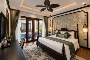 A bedroom with a large bed, a ceiling fan, a view of an outdoor pool, and a wall with floral wallpaper. - Cozy An Boutique Hotel Luangprabang (Luang Prabang)