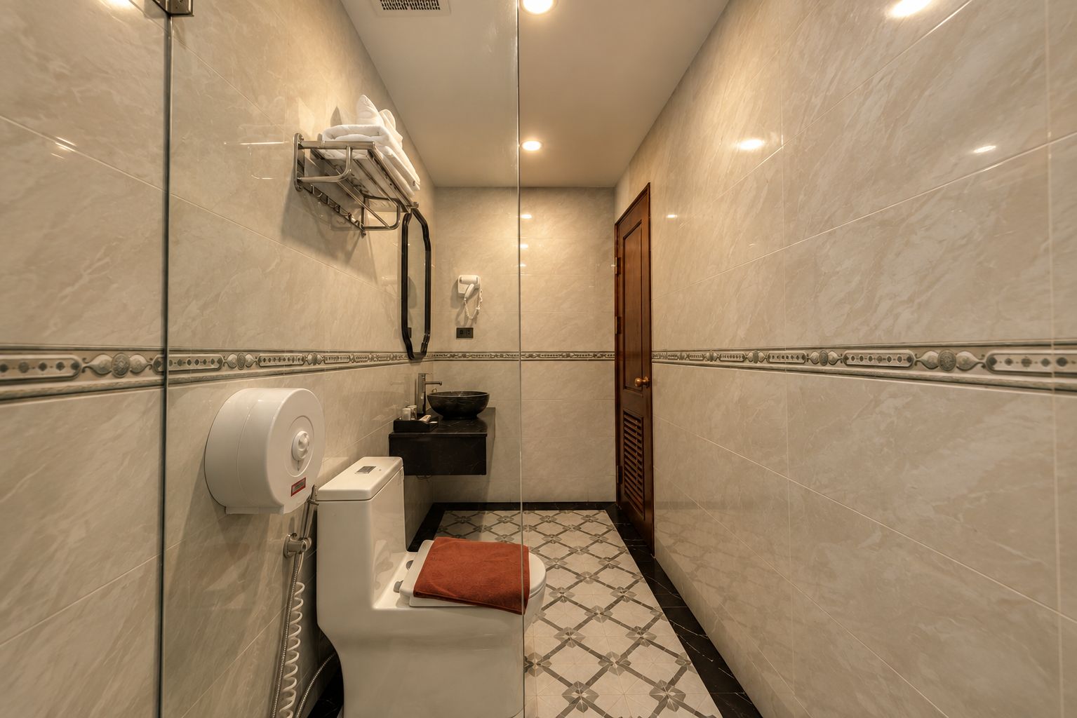Une salle de bain comprenant des toilettes, un lavabo et un espace douche.