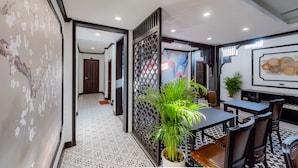 A modern dining area with a black table and chairs, a decorative plant, and a patterned floor. - Cozy An Boutique Hotel Luangprabang (Luang Prabang)