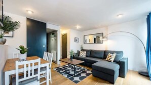 Una sala de estar moderna con sofá, mesa de centro y comedor.