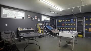 A room with a foosball table, a trampoline, and a basketball hoop.