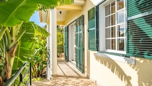 A corridor with a tiled floor, green shutters, and a white wall. - Sunny House by Homie (Ponta do Sol)