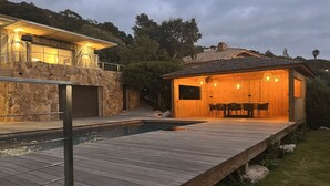 A wooden house with a pool and a patio area.