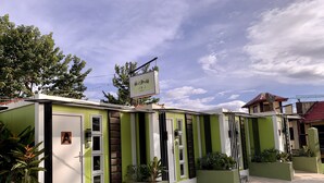 Una hilera de unidades de hotel modulares, en tonos verde y blanco, con un letrero en la parte superior.