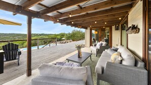 Un espace extérieur aménagé, abrité et doté d’une piscine, d’une terrasse en bois et d’une vue sur le paysage.