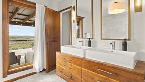 Une salle de bain avec deux lavabos, des meubles en bois et un grand miroir.