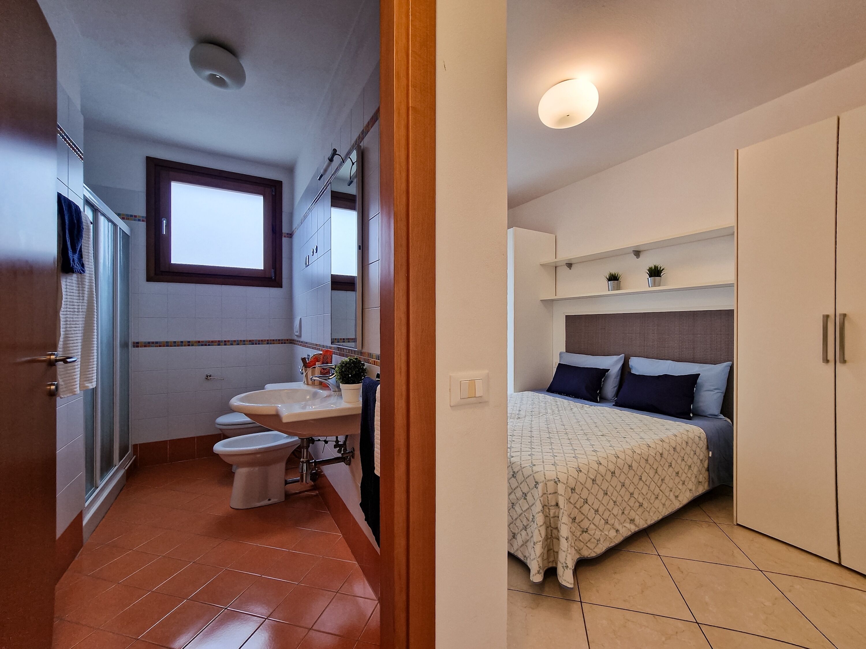 Una camera da letto compatta con un letto, comodini e un armadio.