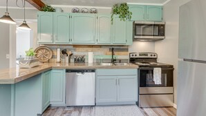 A kitchen with teal cabinets, stainless steel appliances, and a wooden countertop. - Lovely Smoky Mountain Cottage w/ Deck + Views! (Topton)