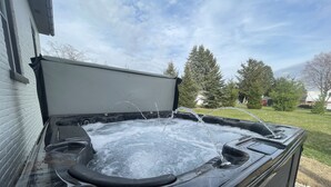 Jacuzzi con chorros de agua, con árboles y cielo despejado como fondo residencial.