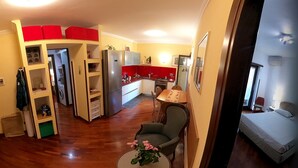 Um espaço compacto com cozinha compacta, área de refeições e quarto.