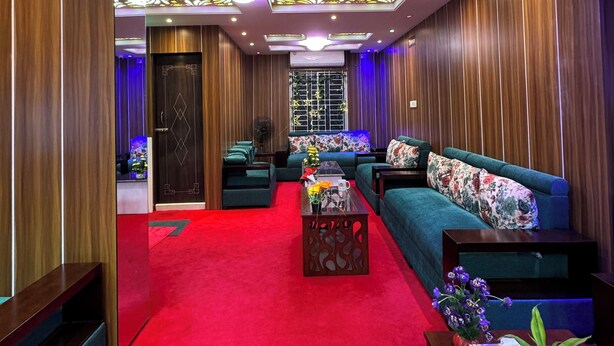 A modern living room with a red carpet, wooden panel walls, and a blue sofa.