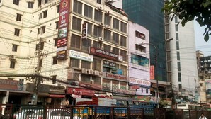 A multi-story building with various signs, including a hotel and a business center.