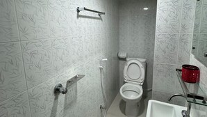 A bathroom with a toilet, sink, and shower.