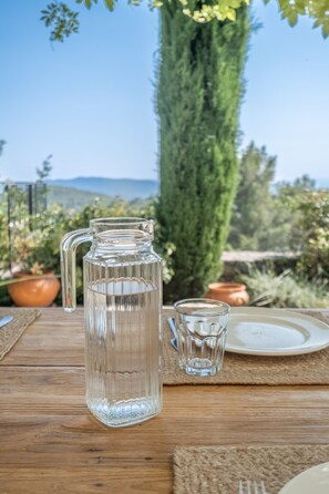 Enjoy a refreshing drink on the outdoor table amidst lush surroundings.