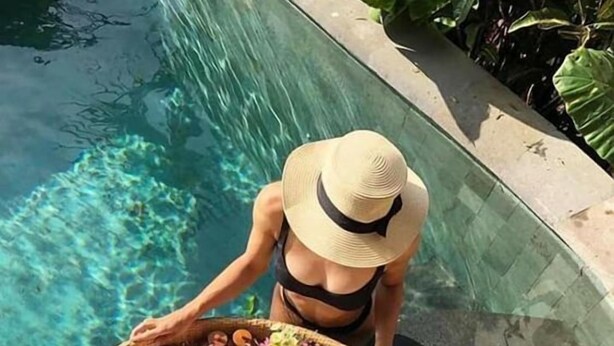 A person by a poolside with a tray of food and drinks. - Arvanya Villa Ubud (Tegallalang)
