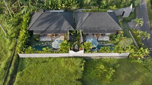 An aerial view of a resort with two separate buildings, each with a swimming pool and surrounded by lush greenery. - Arvanya Villa Ubud (Tegallalang)