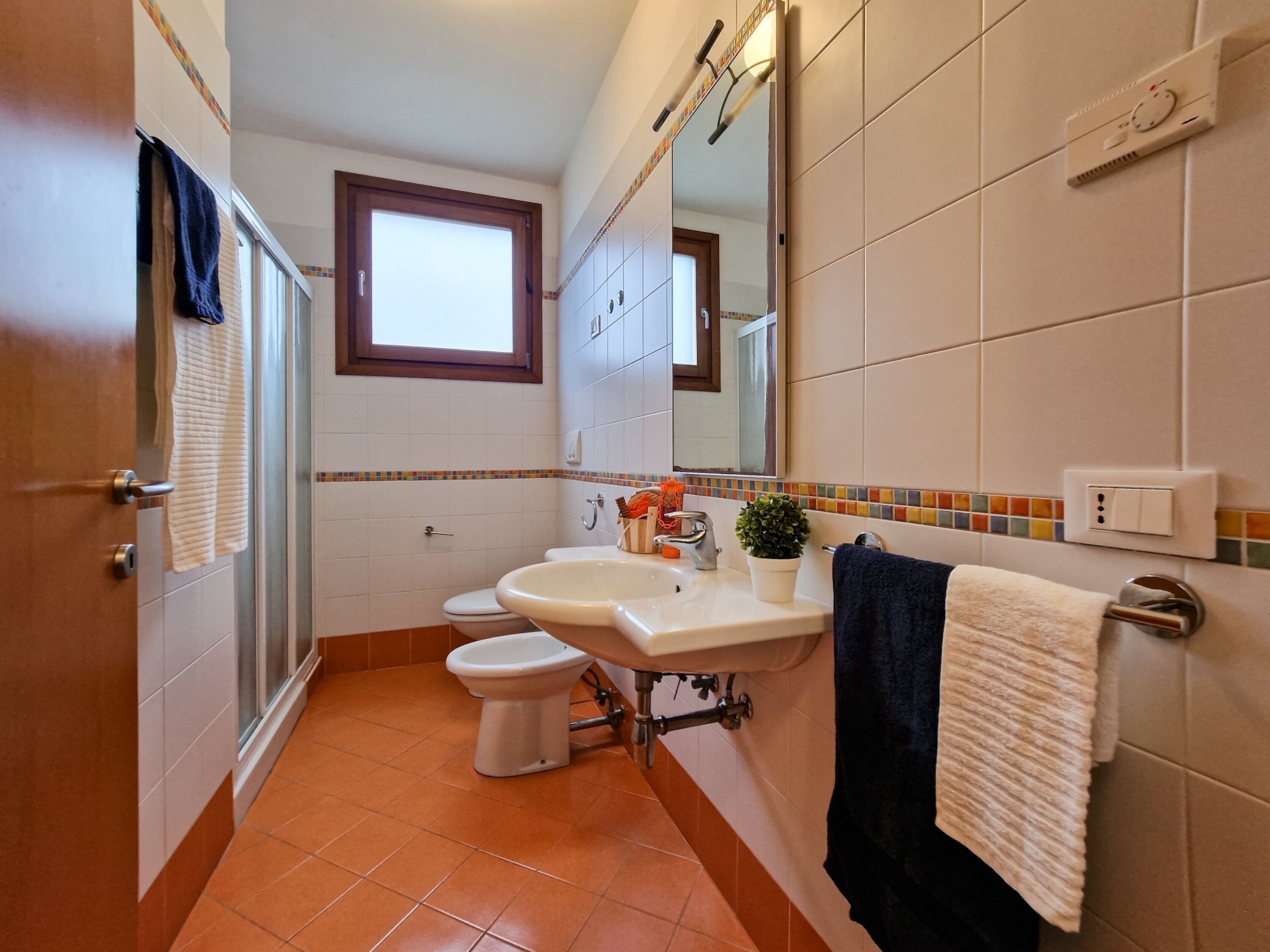 A bathroom with a toilet, sink, and shower.