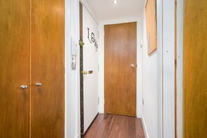 A hallway with wooden doors and a white wall with a 'Love' sign.