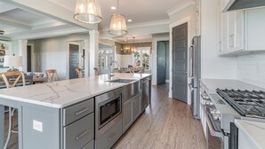 A modern kitchen with a large island, stainless steel appliances, and pendant lighting. - Barnacle Bill's: Private Pool w/dock & Ramp (Murrells Inlet)