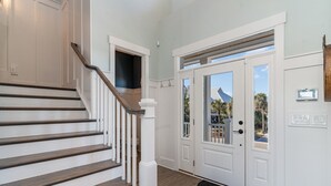 A staircase with wooden steps and white railings, leading to a door with glass panels and a view of the outdoors. - Barnacle Bill's: Private Pool w/dock & Ramp (Murrells Inlet)