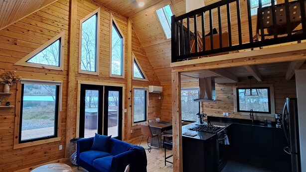Una cabaña con habitación entre piso, comedor y cocina.