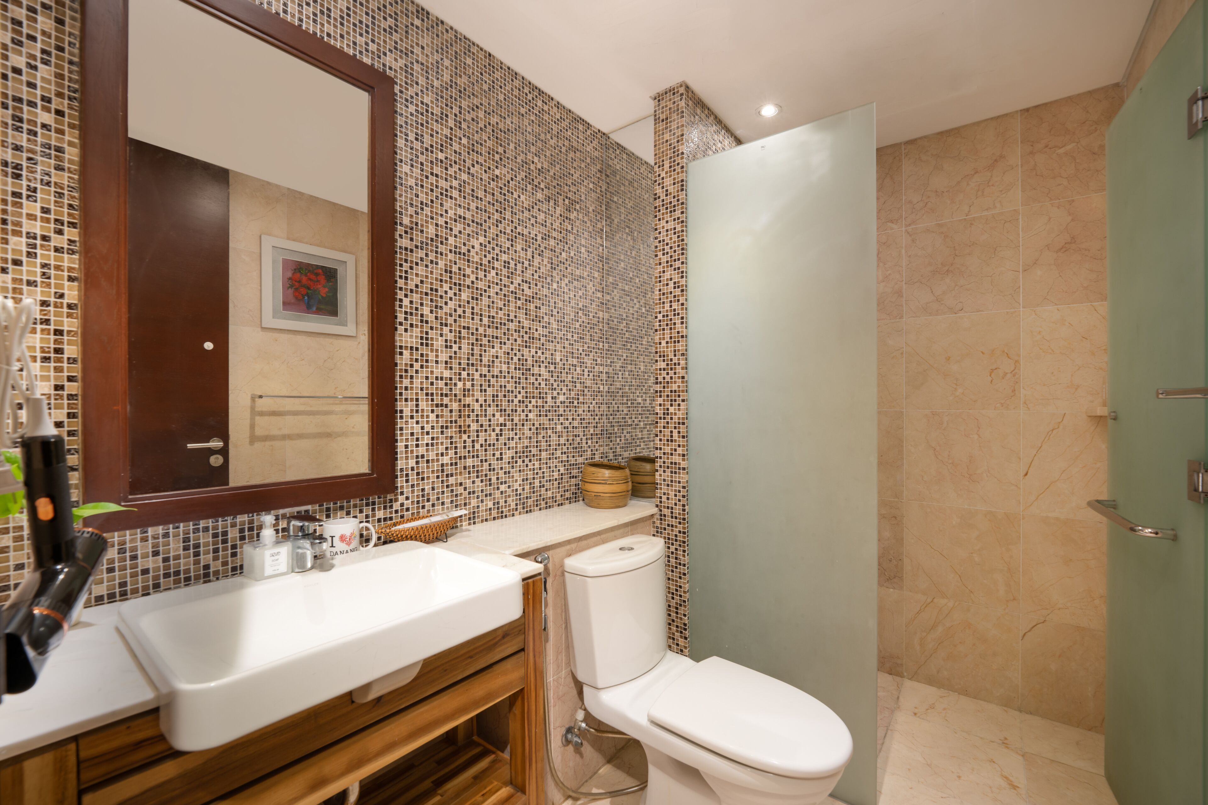 A bathroom with a white sink, a toilet, and a shower area.