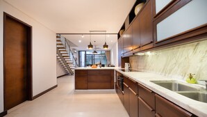 Una cocina moderna con armarios de madera oscura, una encimera de mármol y un horno empotrado.
