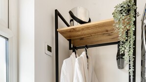 Een badkamer met een houten plank, een witte badjas en een paar slippers.