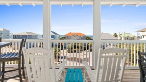 A covered outdoor area with white railings and wooden chairs. - Pool | Elevator | Sleeps 10 (Cape San Blas)