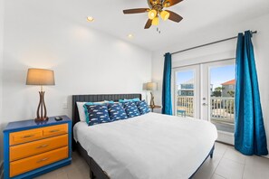 A bedroom with a bed, a nightstand, a lamp, and a ceiling fan. - Pool | Elevator | Sleeps 10 (Cape San Blas)