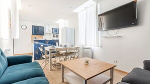 Una sala de estar moderna con un sofá, una mesa de centro y un televisor montado en la pared.
