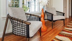 A room with two wicker chairs, a large window, and a colorful striped rug. - Coastal Farmhouse at Ninigret Pond - 3.1 Mi to beach - Sleeps 4-12 people (Charlestown)