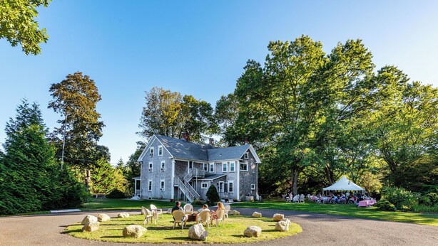 A large stone building with a central staircase, surrounded by a well-maintained lawn and trees. - Coastal Farmhouse at Ninigret Pond - 3.1 Mi to beach - Sleeps 4-12 people (Charlestown)