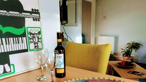 A dining table with a bottle of Merlot, glasses, and a woven basket of fruits. - Private Entire House - 3 Bedrooms, Garden, Parking (Brighton)