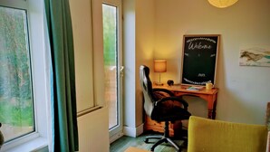 A room with a wooden table, a wicker fruit bowl, a desk with a chair, a lamp, and a 'Welcome 2023' sign on the wall. - Private Entire House - 3 Bedrooms, Garden, Parking (Brighton)