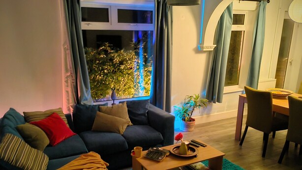 A living room with a sofa, coffee table, and a dining area with chairs. - Private Entire House - 3 Bedrooms, Garden, Parking (Brighton)