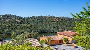 Una villa con techo de tejas, rodeada de exuberante vegetación y un lago.