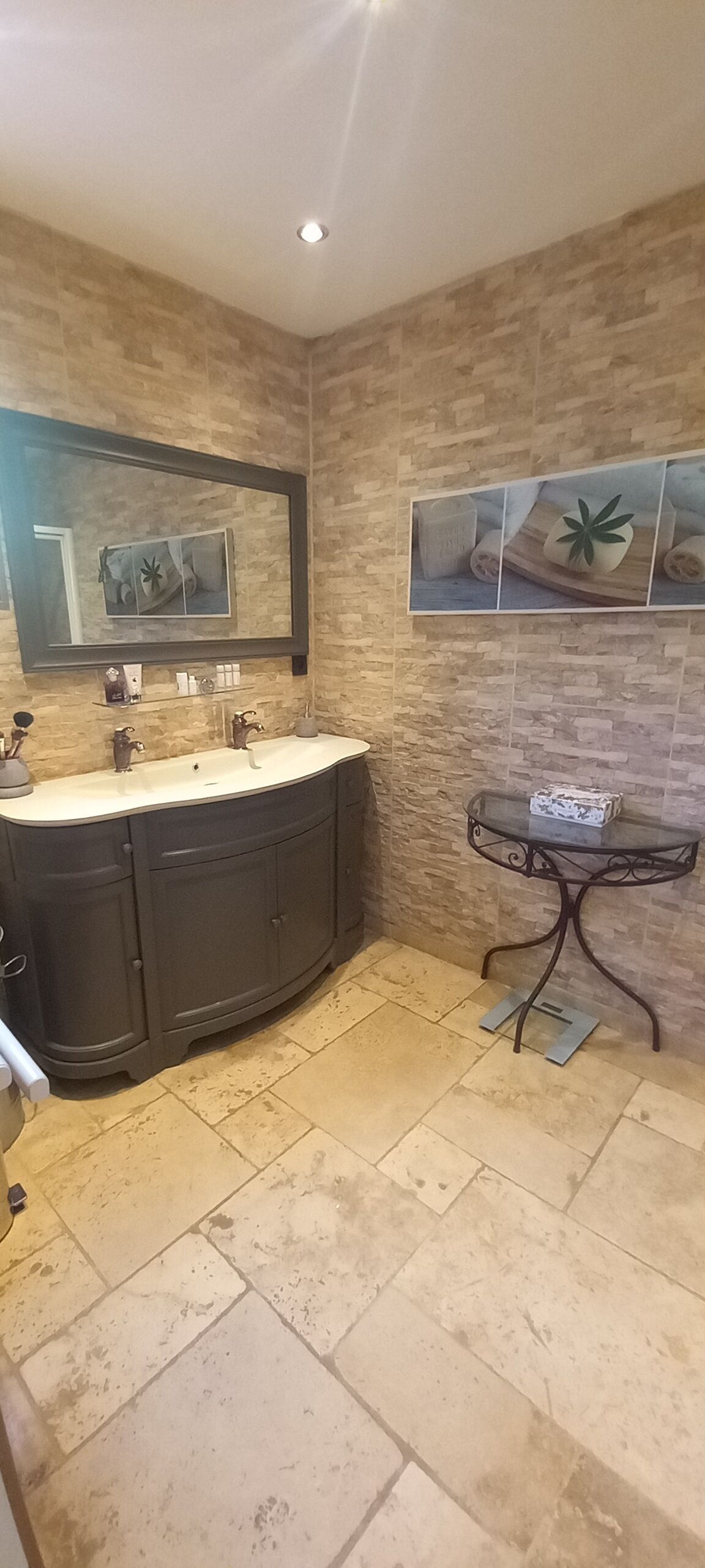 Un baño con un lavamanos espacioso, un espejo y un estante en la pared con artículos de tocador.