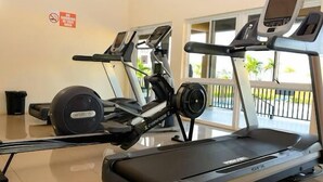 A gym with treadmills, a stationary bike, and a rowing machine. - Captivating 2-bed House in Falmouth (Falmouth)