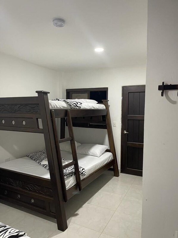 A bunk bed with a headboard, a door, and a light fixture on the ceiling.