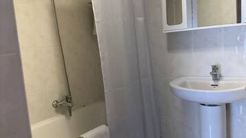 A bathroom with a bathtub, a shower, a sink, and a toilet.