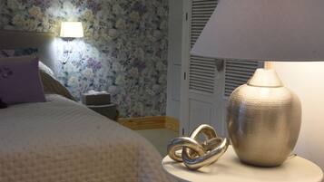 A bedroom with a bed, a nightstand, a lamp, and a decorative item on the nightstand.