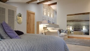 A bedroom with a large bed, a wooden door, a mirror, and a view of a balcony. - Les Girauderies Chambres d'Hotes  (Floirac)