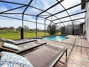 En täckt uteplats med en pool, solstolar och utsikt över det omgivande landskapet.