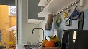 Une cuisine moderne dotée d’un plan de travail en marbre, d’un évier et d’un panier à fruits.