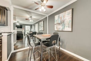 Una cocina moderna con comedor, que incluye una mesa de madera, sillas y ventiladores de techo.